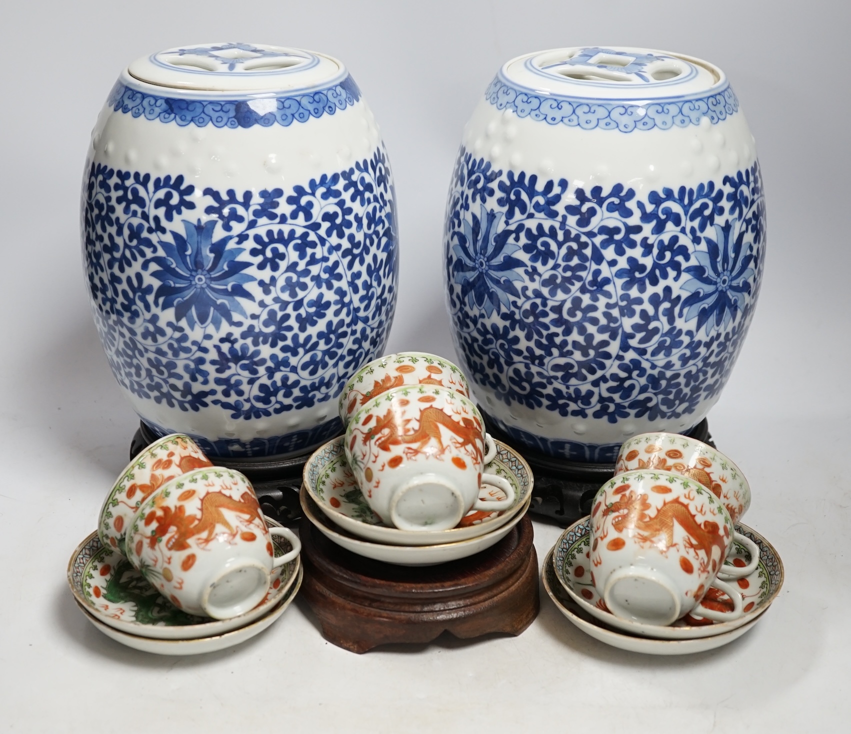 A pair of Chinese blue and white barrel jars, various cups and saucers and three hardwood stands, largest 21cm high